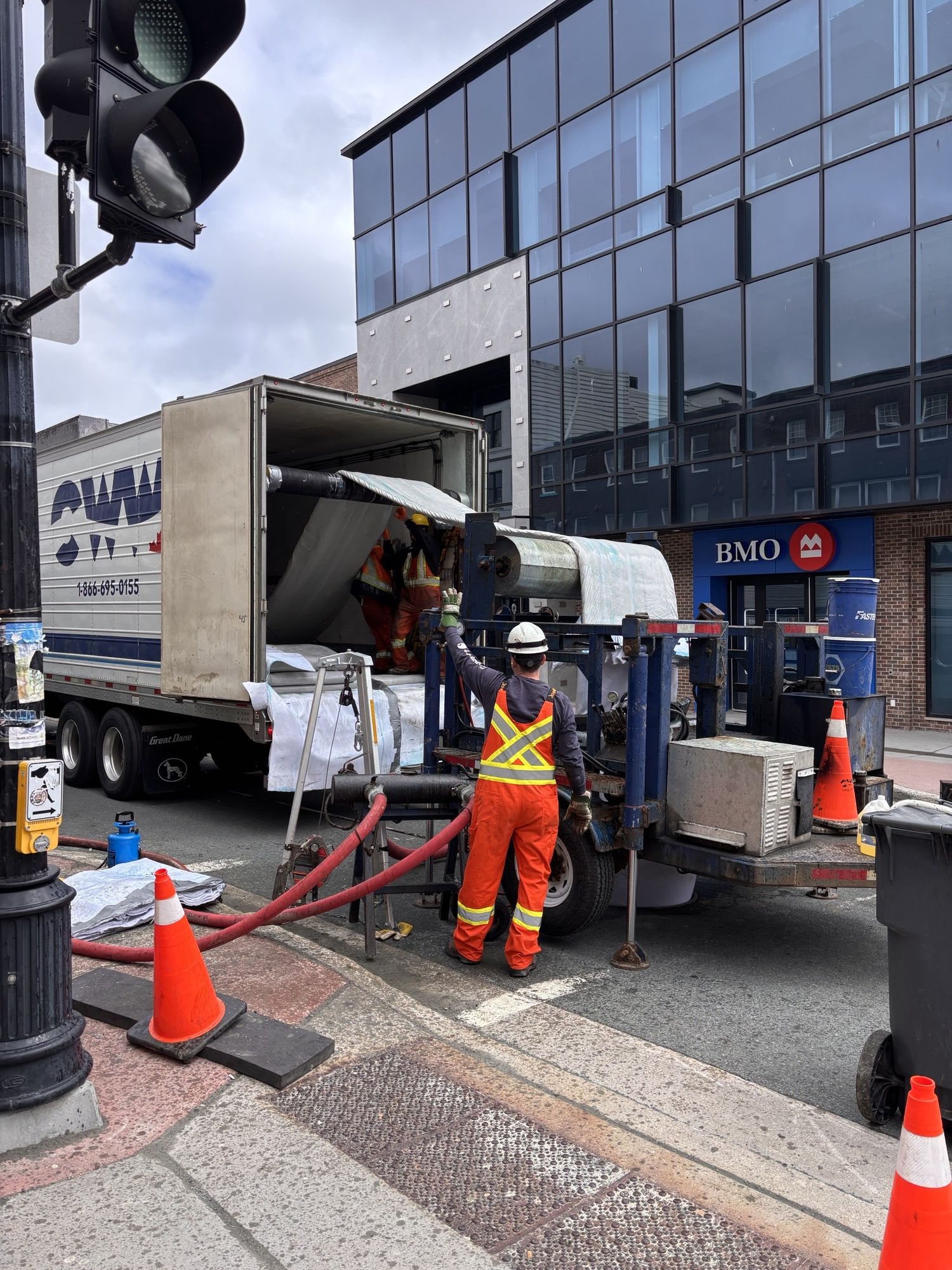 Photo of a construction worker feeding the CIPP liner through the manhole on Water Street